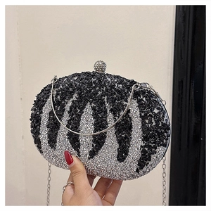 Detailed shot of sparkling rhinestone pumpkin clutch with silver wavy patterns and metal handle