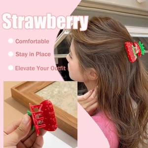 Detail view of red strawberry hair claw clip showing model wear and acrylic texture