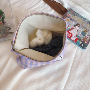 Internal view of purple and pink checkered canvas pouch showing beige lining and smooth zipper
