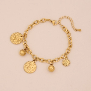 Dettaglio di ciondoli a luna e stella dorati con texture martellata su bracciale in acciaio