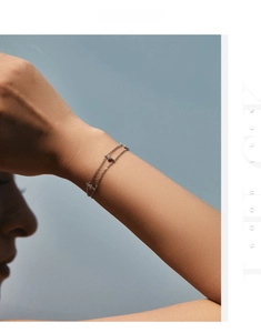 Detail of double-layer S925 sterling silver chain bracelet with delicate cubic zirconia charms