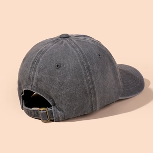 Detail of washed dark grey baseball cap showing metal buckle and retro cotton texture