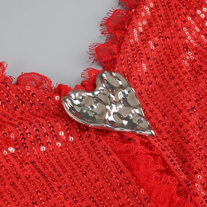 Detail of red sequin dress featuring a silver lava-textured heart-shaped buckle