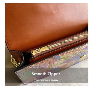 Detail shot of golden metal zipper and shimmering snakeskin pattern on the crossbody bag
