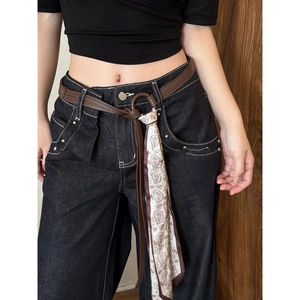 Vintage red silk scarf belt with brown leather details styled on dark high-waist jeans