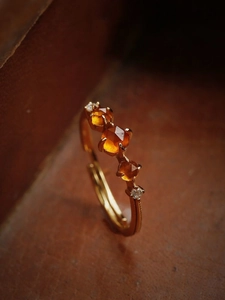 Macro shot of vintage gold-plated ring with orange garnet and hexagonal cut gemstones