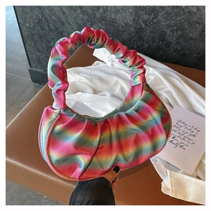Close-up of pleated rainbow gradient handbag with circular handle and satin finish