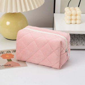 Pink quilted corduroy makeup bag with lattice pattern and white zipper closure