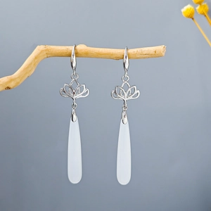 Traditional Chinese silver lotus earrings with long white teardrop tassels on wooden branch