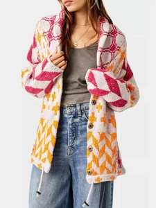Detail of color-block knit cardigan with pink orange and white geometric patterns and buttons