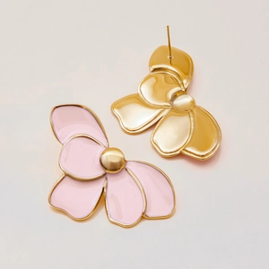 Detailed view of large gold and pink enamel flower stud earrings with a smooth finish