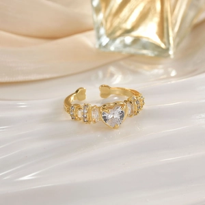 Close-up of golden heart-shaped gemstone ring with micro-set stones and adjustable open band