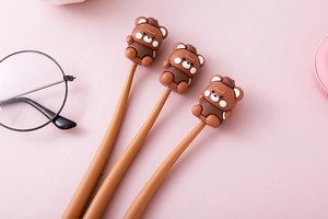 Detailaufnahme von drei braunen Bären-Gelschreiber mit Retro-Brille auf rosa Untergrund