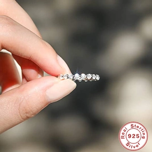 Macro detail of 925 sterling silver eternity ring band with sparkling small gemstones