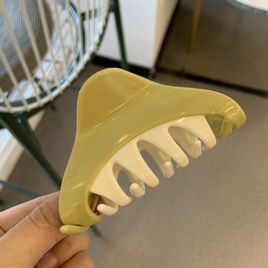 Detail view of large bicolor hair claw clip in yellow-green and white plastic finish
