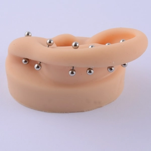 Close-up of silver stainless steel ball stud earrings on a silicone ear model