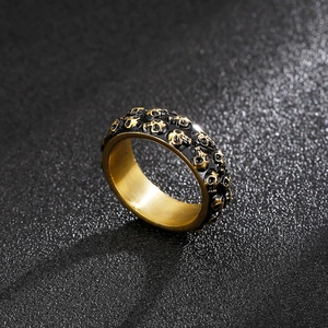 Makroaufnahme von Punk-Totenkopfring in Gold und Schwarz mit Vintage-Reliefverzierung