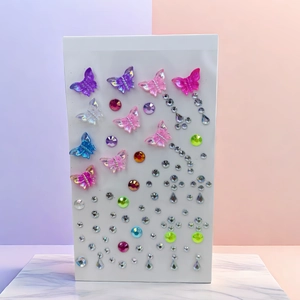 Detail of colorful butterfly acrylic gems and teardrop resin rhinestones for face makeup