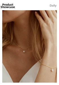 Close-up of minimalist freshwater pearl necklace and bracelet set in 18K gold plated steel