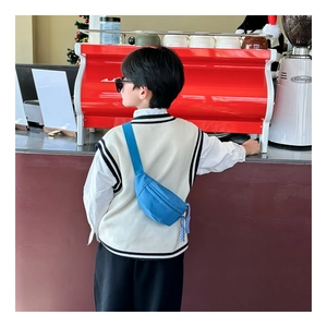 Close-up of bright blue nylon kids chest bag worn crossbody on back in cafe setting