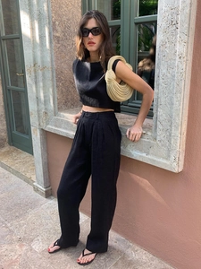 Detail des minimalistischen schwarzen ärmellosen Leinentops und der weiten Hose mit hohem Bund