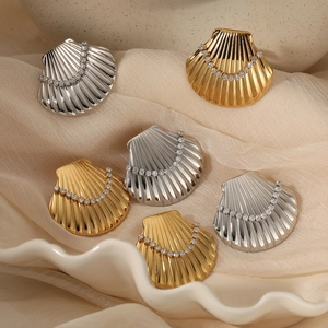 Golden and silver shell-shaped jewelry sets with zircons on elegant beige fabric
