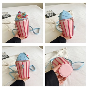 Detail view of a pink cupcake crossbody bag with cherry decor and gold chain strap