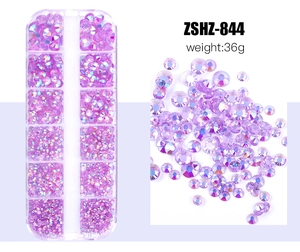 Macro detail of mixed purple resin rhinestones for nail art in a 12-grid storage box