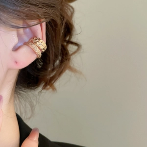 Close-up of gold double-layer ear cuff set with hammered metal and sparkling zircon detail