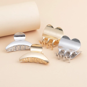 Set of four small metal hair claws in gold and silver heart and crescent shapes