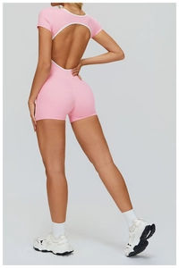 Close-up of the open-back design with contrast white piping on a pink fitness romper