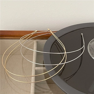 Minimalist double layer wavy metal headbands in gold and silver finish on textured tray