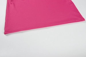 Detail shot of the hemline of a rose pink knit backless dress with neat double stitching
