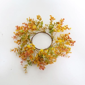 Detail view of eucalyptus leaf candle ring with autumn gradient orange and yellow foliage
