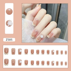 Set unghie finte nude stile francese con elegante camelia bianca e decorazioni di perle