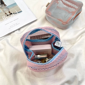 Mesh makeup bag detail showing internal compartments with lipstick and powder