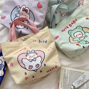 Flat lay of colorful canvas tote bags with cute cartoon prints on a soft white background