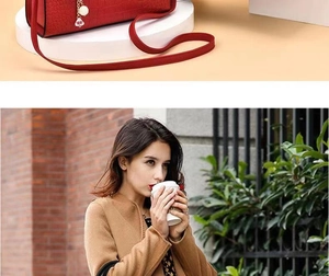 Detail of red embossed leather handbag featuring pearl and diamond gold zipper pendant