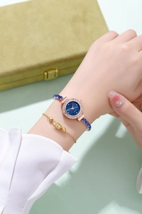 Close-up of a women's quartz watch with blue beaded strap and matching gold bracelet