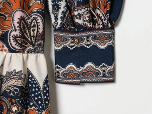 Detail von Paisley-Print-Ärmel in Marineblau mit goldenem Knopf auf Webstoff