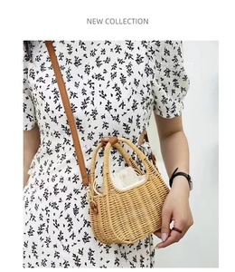 Straw handbag with leather straps and drawstring inner bag shown on a model