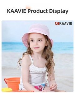Pink wavy brim sun hat for kids shown on a beach with a sand bucket prop