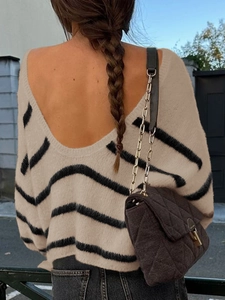 Detail of knitted striped sweater featuring a stylish open back design for women
