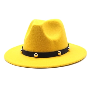 Detail of a bright yellow wool fedora hat with a black band and gold stud embellishments