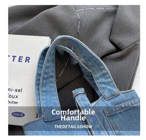 Detail of blue denim bucket bag featuring brown stitching and silver metal ring hardware