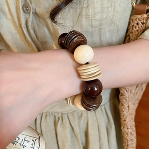 Macro view of vintage beaded bracelet featuring coconut shell discs and dark wood beads