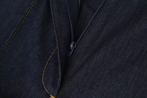 Vue macro détaillée de la fermeture éclair en denim bleu foncé avec coutures contrastées