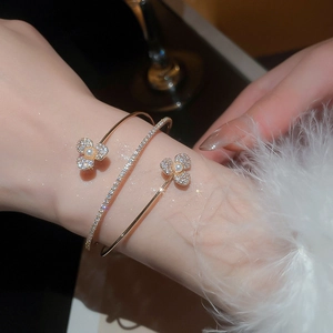 Detail of a double-layer gold bangle with zircon flowers and pearls on a wrist