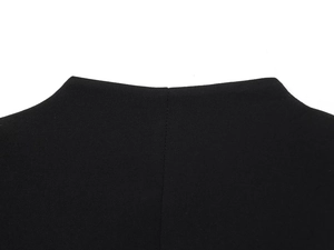 Close-up of black blazer dress showing textured fabric and precision stitching details
