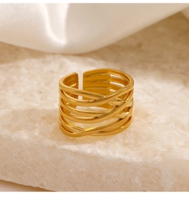 Close-up of 18K gold-plated multilayer criss-cross ring on a stone pedestal with silk